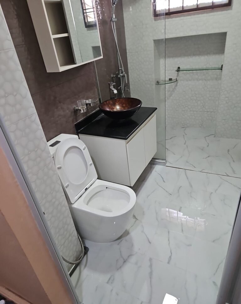 Completed toilet renovation with marble-effect tiling and vessel basin